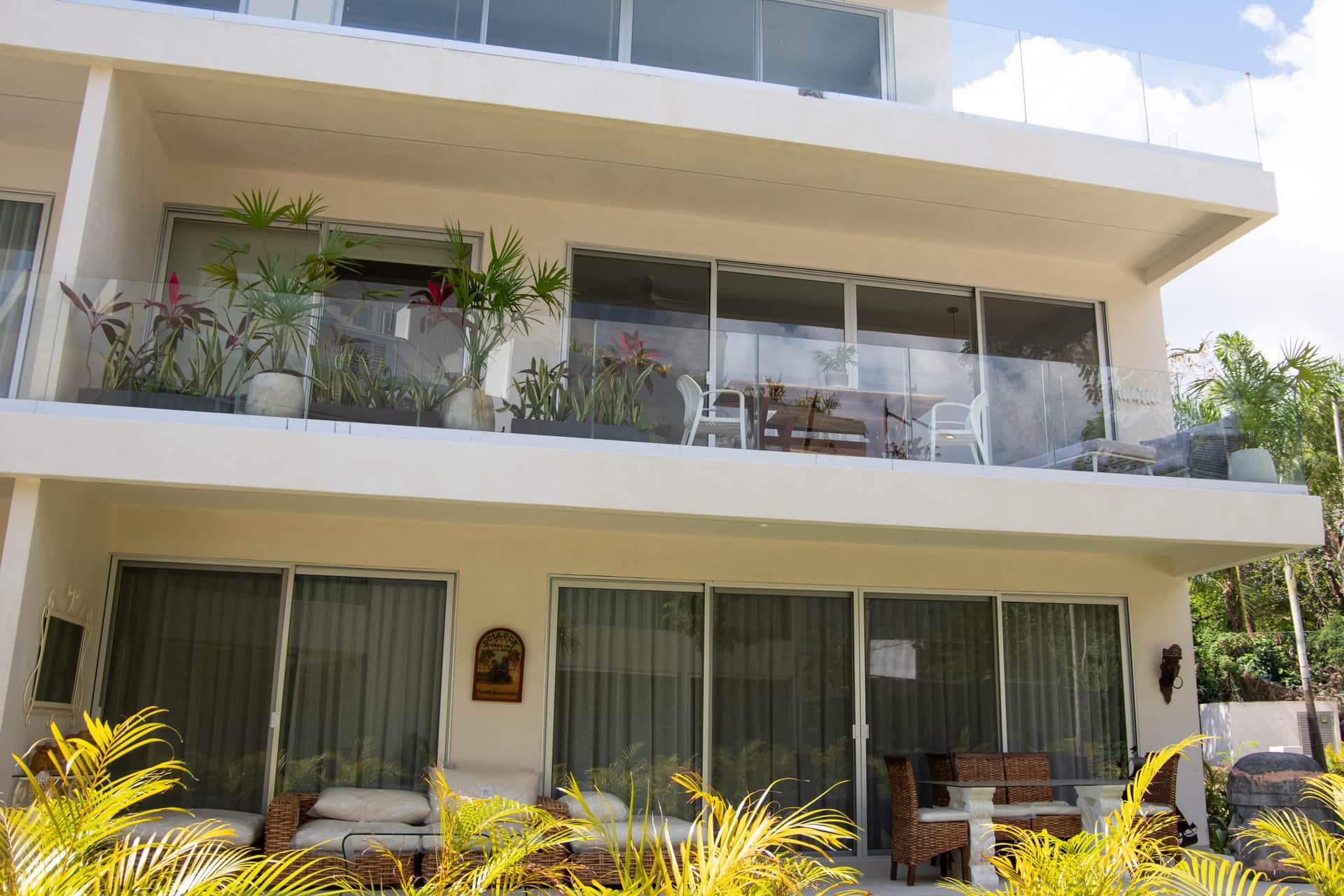 Ground-floor terrace with outdoor dining and tropical plants at The Leaf Playacar