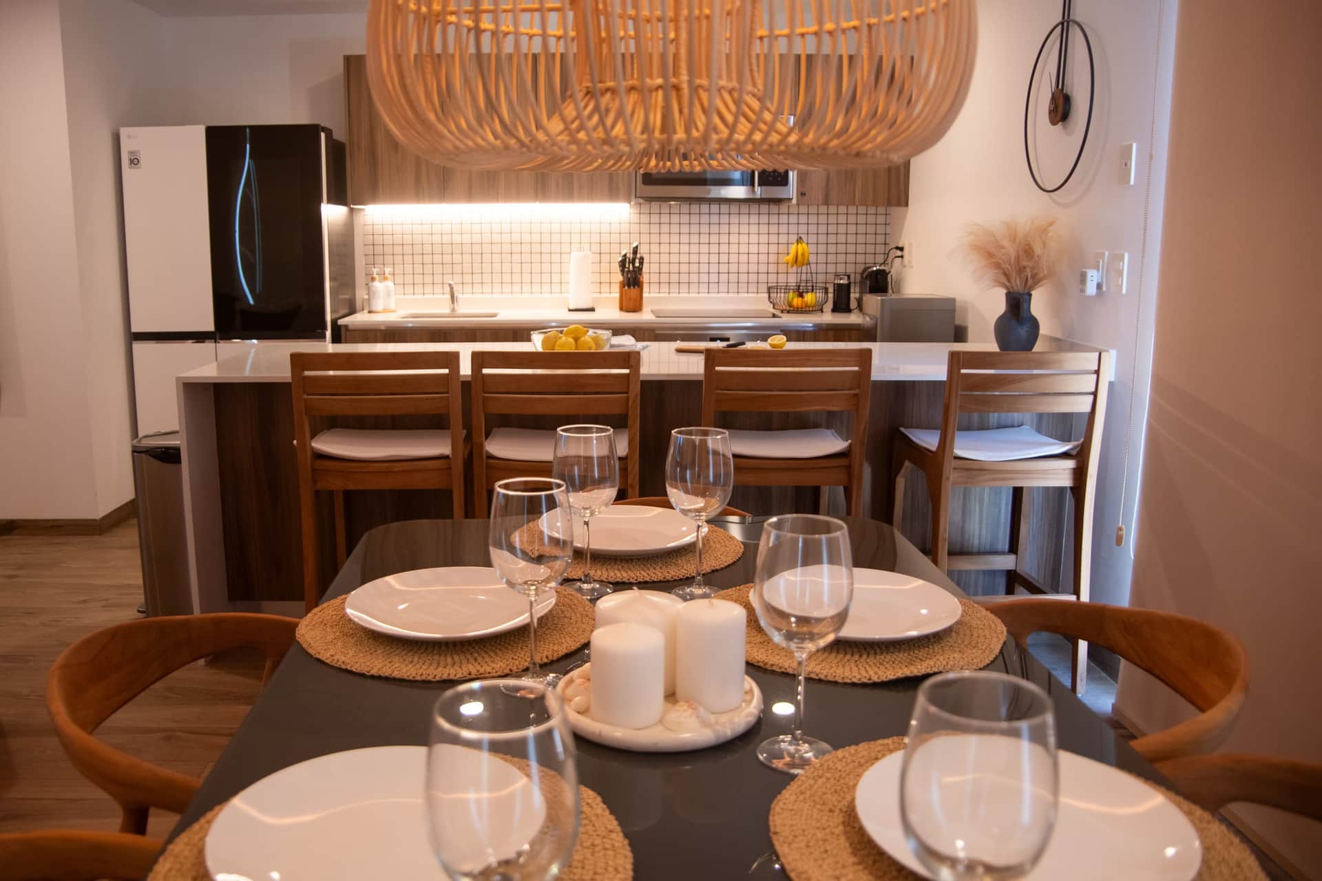 Modern gourmet kitchen and dining area with wood cabinetry at The Leaf Playacar