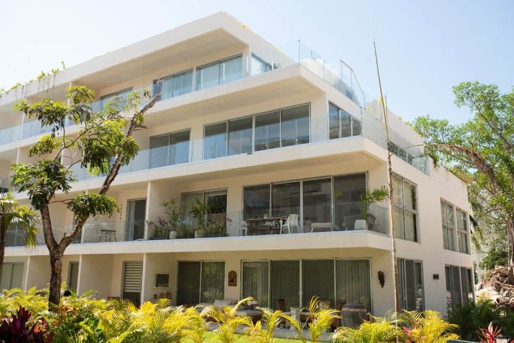 The Leaf Playacar modern white four-story villa with glass balconies and tropical landscaping