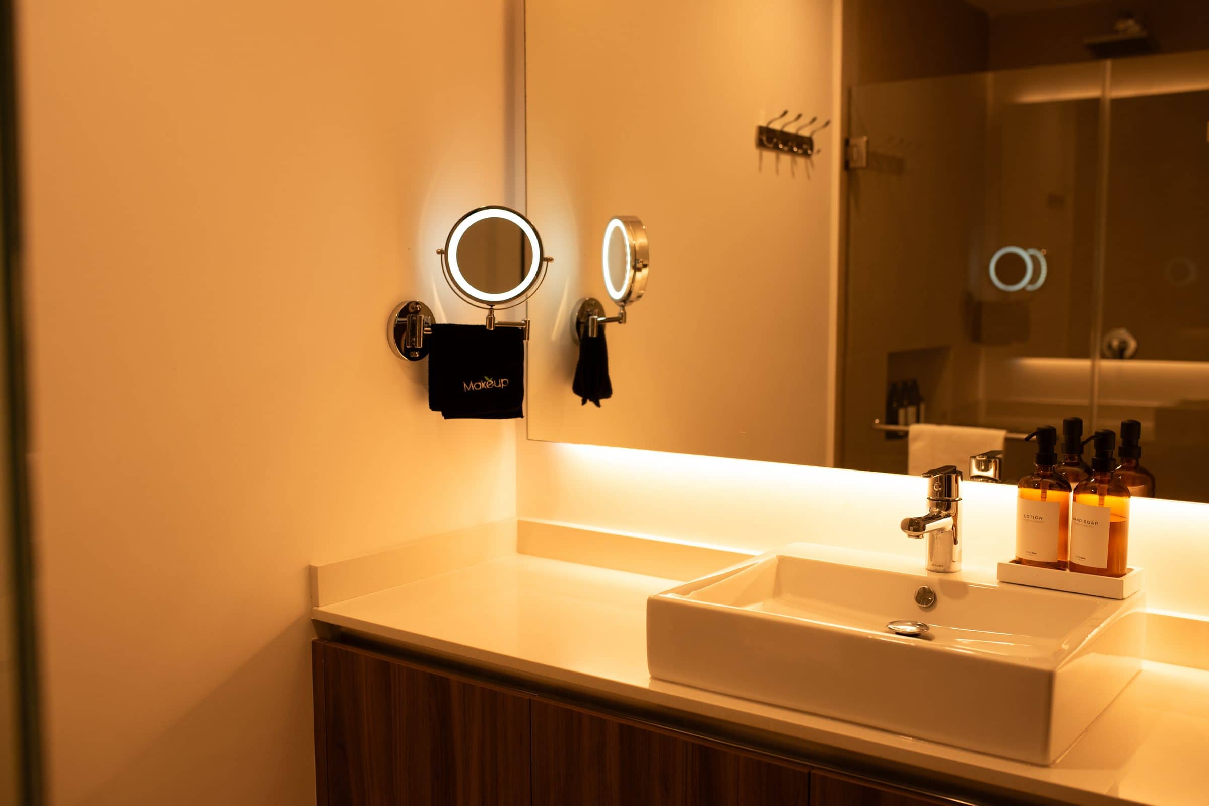 Designer bathroom vanity with warm lighting at The Leaf Playacar