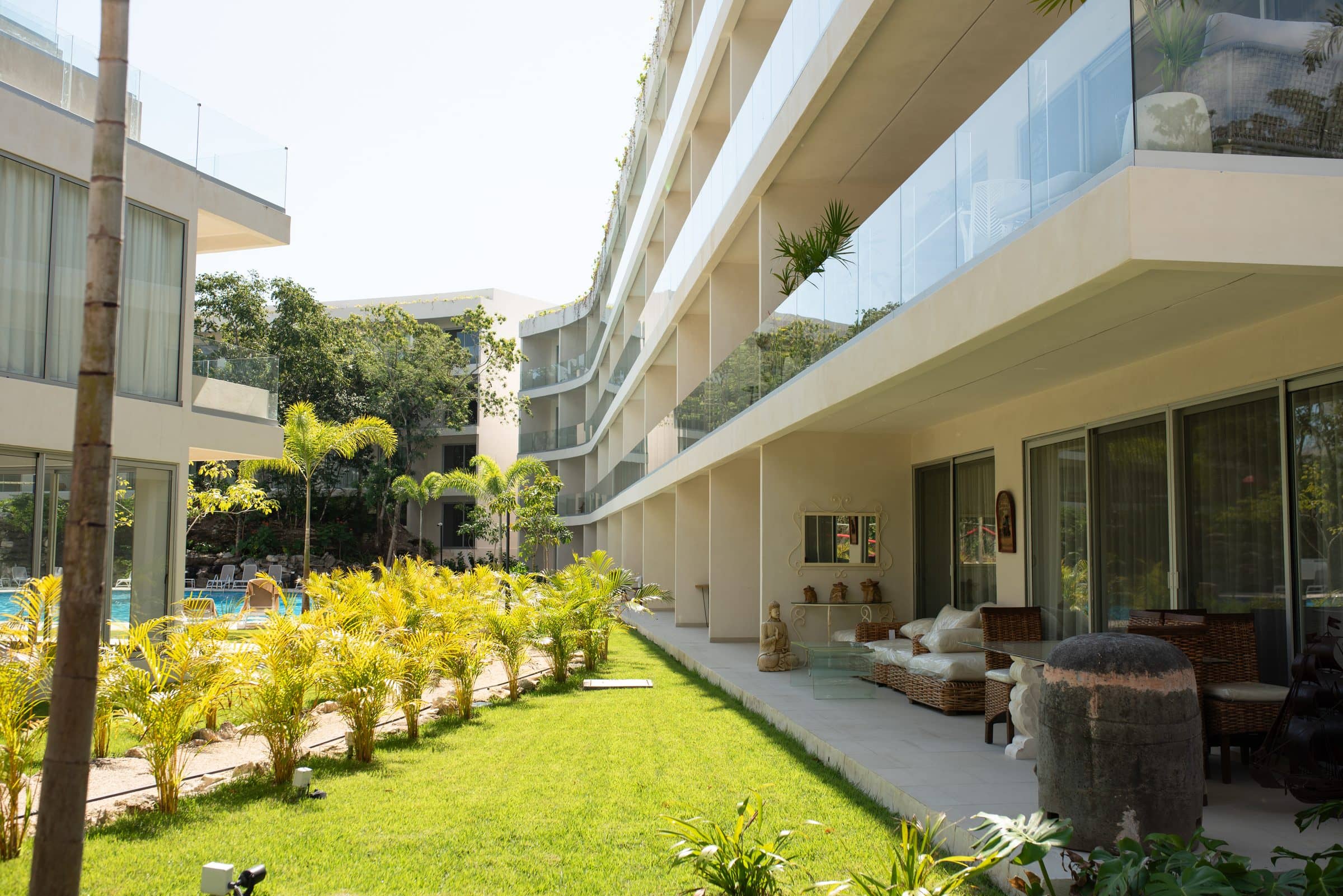 Curved modern building with pool and tropical garden at The Leaf Playacar