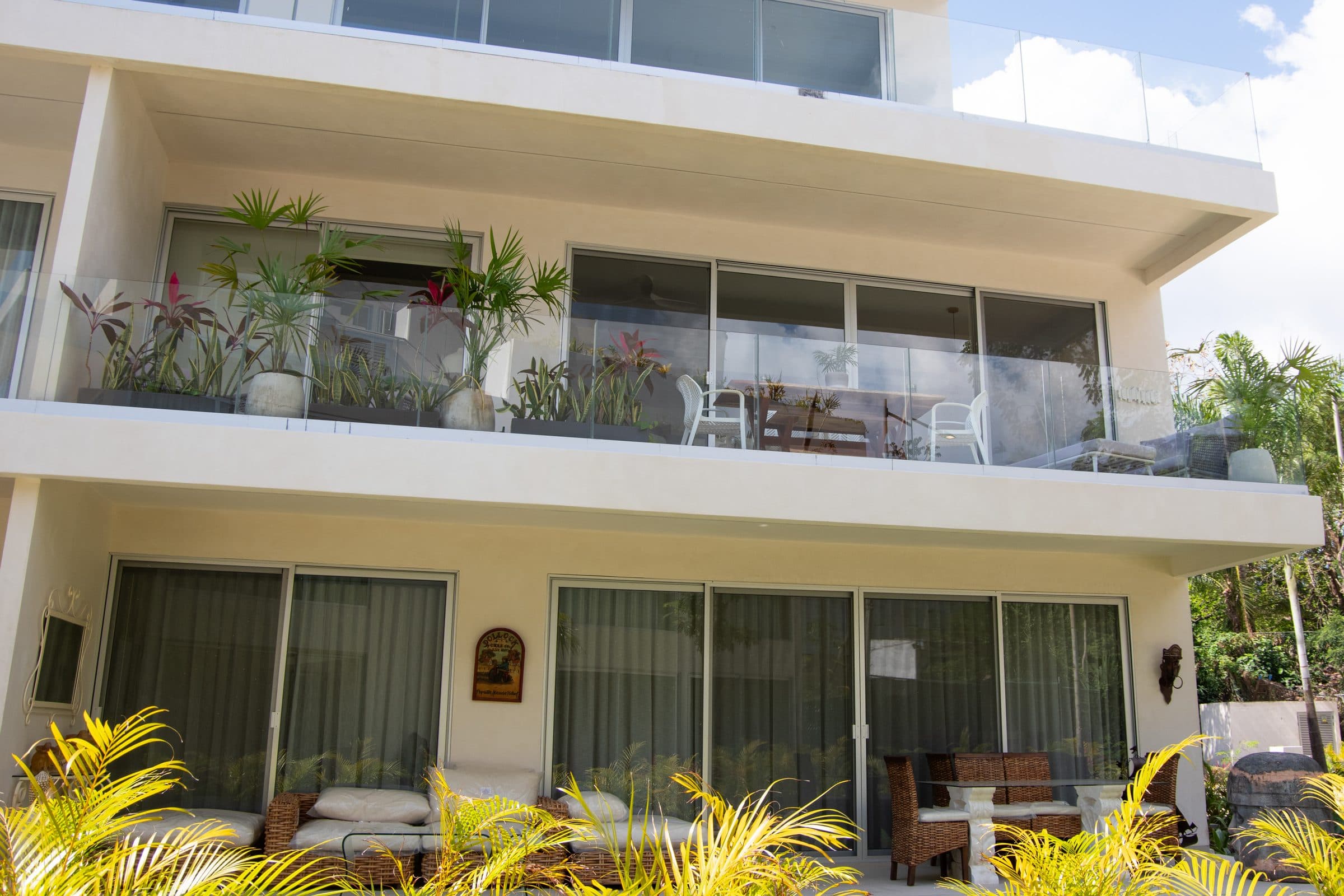 Ground-floor terrace with outdoor dining and tropical plants at The Leaf Playacar
