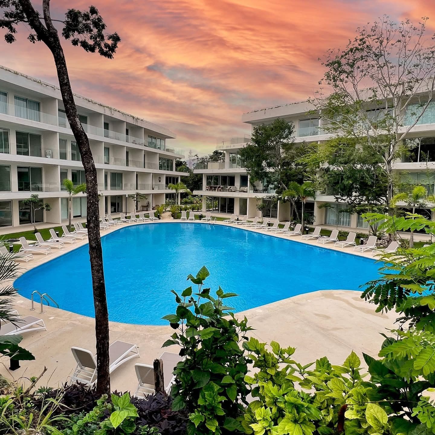 Community pool at The Leaf Playacar during golden hour sunset